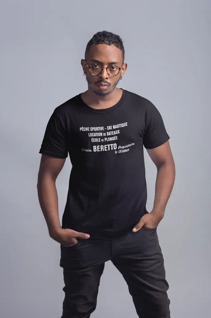 Antoine_Beretto_t-shirt-mockup-of-a-serious-man-wearing-large-round-glasses-21056.webp